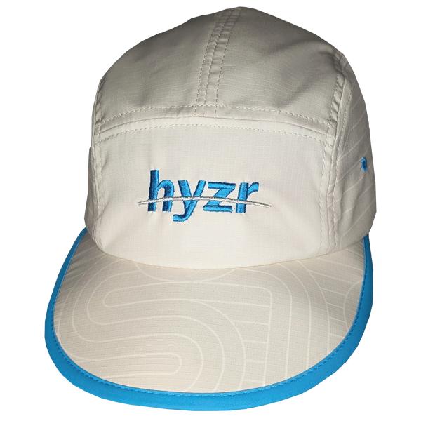 Front view of the Styx Trail Hat. Cement colored 5-panel hat, with a zen garden print and pops of electric blue.