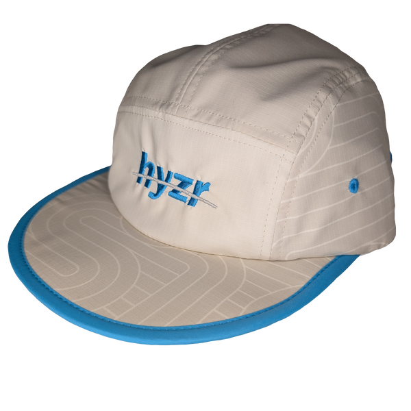 45 degree view of the Styx Trail Hat. Cement colored 5-panel hat, with a zen garden print and pops of electric blue.