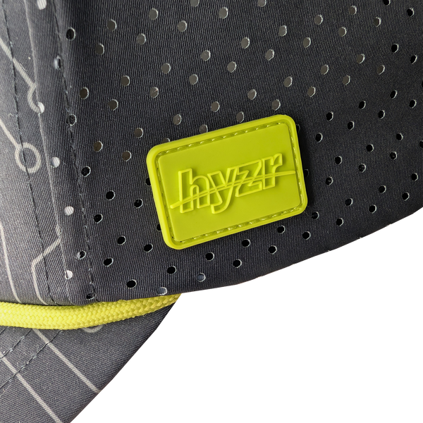 Closeup of the Hyzr logo on a yellow rubber patch.
