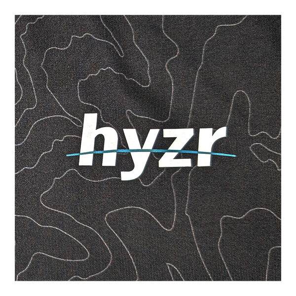 Hyzr logo closeup on charcoal fabric with topographical print