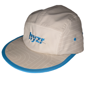 45 degree view of the Styx Trail Hat. Cement colored 5-panel hat, with a zen garden print and pops of electric blue.